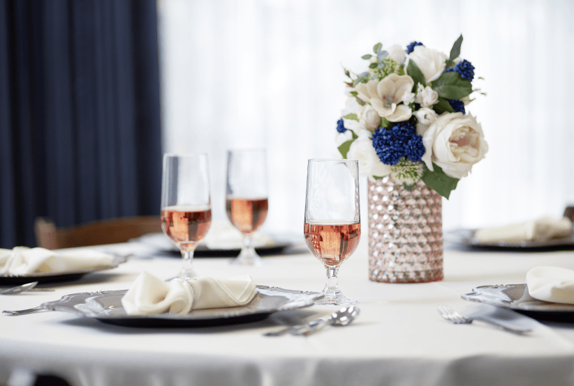 Table arrangement with three glasses of rose and an elegant flower arrangement